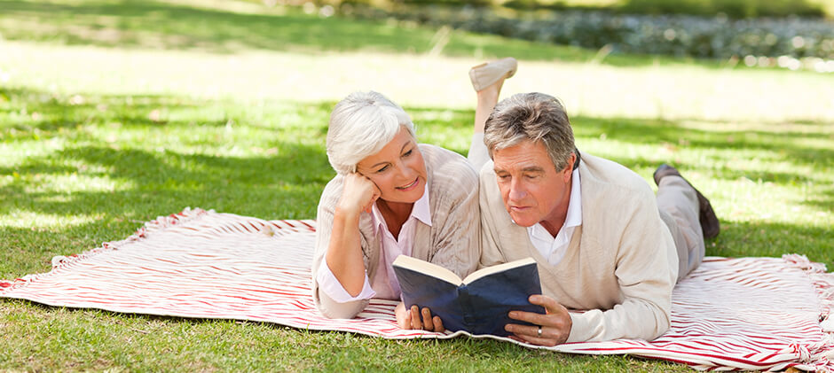 Mature couple reading together in park